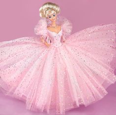 a barbie doll wearing a pink dress with gold stars on it's skirt and headband