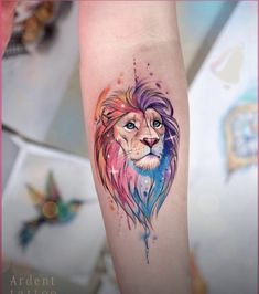 a colorful lion tattoo on the arm