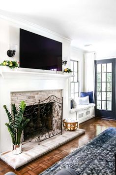 a living room with a fireplace and tv above the mantel in front of it