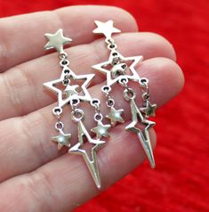 Dull silver tone star charm earrings. Earring length: 52mm; 2" (from the top to end) Earring stud material: 316L stainless steel Charm material: Zinc alloy, Nickel safe, Lead free This listing is for one pair of star earrings with rubber backs. These earrings will come in a gift bag. I offer combined shipping costs which give you a shipping discount for ordering multiple items from my shop. Earrings care: Take them off while you sleep, do sports activities, bathe, having a shower. Avoid contact Nickel-free Star-shaped Metal Earrings, Nickel-free Metal Star Earrings, Nickel-free Star Shaped Metal Earrings, Silver Star-shaped Pierced Earrings, Silver Stainless Steel Star Charm Earrings, Silver Star Charm Earrings In Stainless Steel, Silver Stainless Steel Earrings With Star Charm, Star-shaped Metal Earrings With Dangling Charms, Jewelry Accessories Ideas