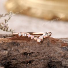 three opal rings sitting on top of a rock