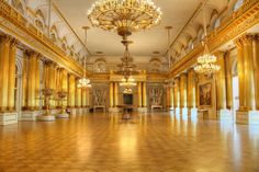 an ornate room with chandeliers and paintings on the walls, in gold hues