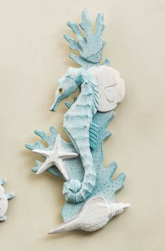 two seahorses are sitting on the wall next to each other, and one is holding a starfish