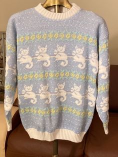 a blue and white sweater with cats on it