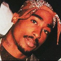 a close up of a person wearing a bandana and looking at the camera with an intense look on his face