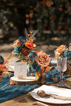 the table is set with flowers and place settings