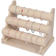 a set of three wooden jewelry racks with bracelets and rings on each one side