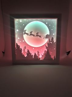 a paper cut christmas scene with santa's sleigh in the sky