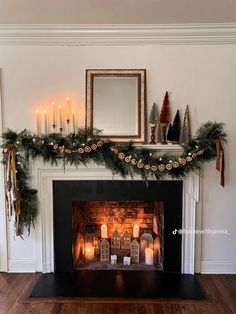 a fireplace decorated with candles and greenery