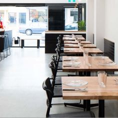 an empty restaurant with wooden tables and chairs