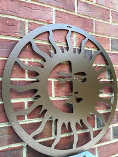 a metal clock mounted to the side of a brick wall