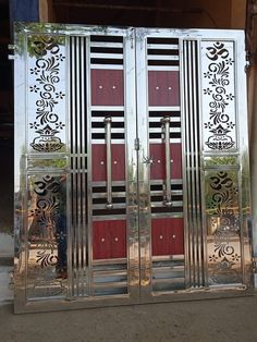 an intricately designed metal door with red doors