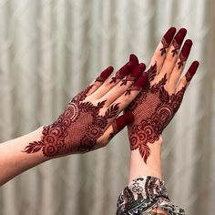 two hands with henna tattoos on their palms