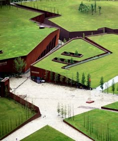 an aerial view of a green field with trees