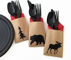 there are forks and spoons wrapped in brown paper with black silhouettes of animals on them