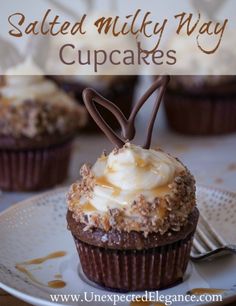 chocolate cupcakes with white frosting and sprinkles on a plate