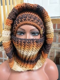 a mannequin wearing a crocheted scarf with a hood on it's head