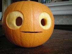 a carved pumpkin with eyes and nose on a table