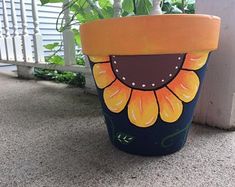 a painted flower pot sitting on the ground