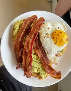 bacon, eggs and avocado on a white plate