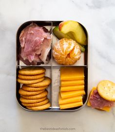 a lunch box with cheese, crackers, fruit and meat