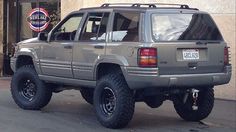 a grey suv parked in front of a building