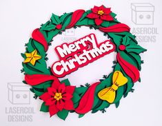 a christmas wreath made out of paper with the words merry christmas written in red and green