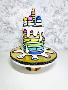 a multi - layered cake with colorful icing and sprinkles on top