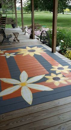 an outdoor deck with painted flowers on the floor and benches in the background at a park