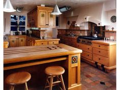 a kitchen with wooden cabinets and stools next to an island in front of the stove