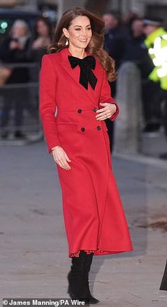 the woman is wearing a red coat and black boots