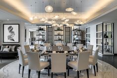 an elegant dining room with marble flooring and white chairs is lit by modern chandeliers