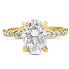 a yellow gold engagement ring with an oval cut diamond in the center and side stones