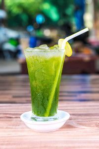 a green drink sitting on top of a wooden table