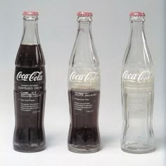 three coca - cola bottles are shown side by side