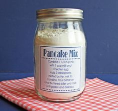 a jar filled with cake mix sitting on top of a red and white checkered cloth