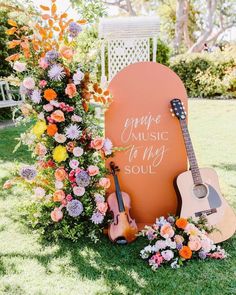 an orange sign with flowers and guitar on it