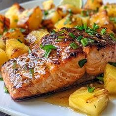 salmon and potatoes on a plate with lemon wedges