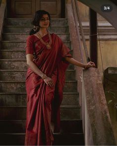 a woman in a red sari standing on some stairs