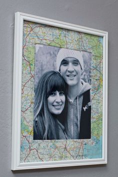 two people are posing for a picture in front of a map