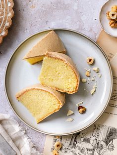 two slices of cake on a plate next to an open book and some walnuts