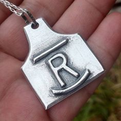 "These personalized, custom cattle and livestock brand ear tag pendants are each hand crafted and hand carved into thick, chunky, solid sterling silver. Your livestock brand can be engraved or 3d raised. Truly a one of a kind item and makes the perfect gift for cowboys and cowgirls! These ear tag pendants hang about 1.5 x 1.25\". They make wonderful gift for ranchers or self indulgence. First photo shows raised brand, second photo shows engraved brand. Chains and shown 10mm \"Navajo Cowgirl Pear Cow Tag Necklace, Livestock Branding, Cow Tag, Cow Ears, Cattle Brands, Cowgirl Gifts, Western Gifts, Ear Tag, Brand Jewelry