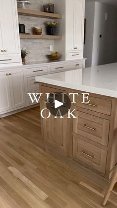 a kitchen with white cabinets and wood floors