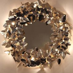 a circular mirror with lights in the shape of leaves