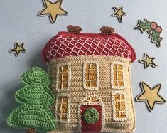 a crocheted house with a christmas tree on the front and stars in the back