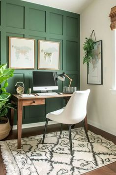 a home office with green paneled walls and white chair in front of the desk