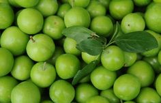 many green apples with leaves on them