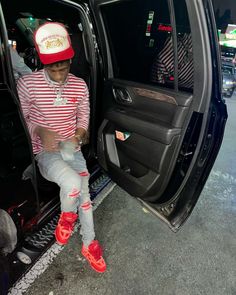 a man sitting in the back of a car with his feet on the door handle