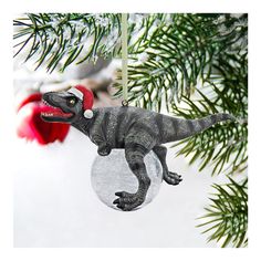 a dinosaur ornament hanging from a christmas tree