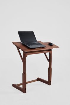 a laptop computer sitting on top of a wooden desk next to a mouse and keyboard